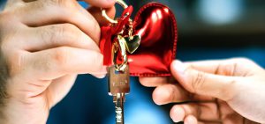 Imagem de duas mãos segurando uma chave com um chaveiro de coração